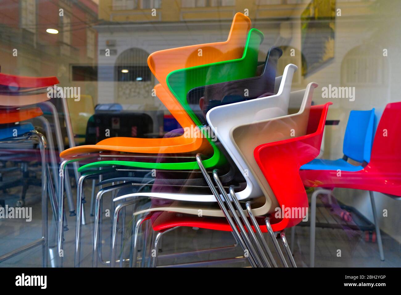 Colorful plastic chairs in a shop window. Stock Photo