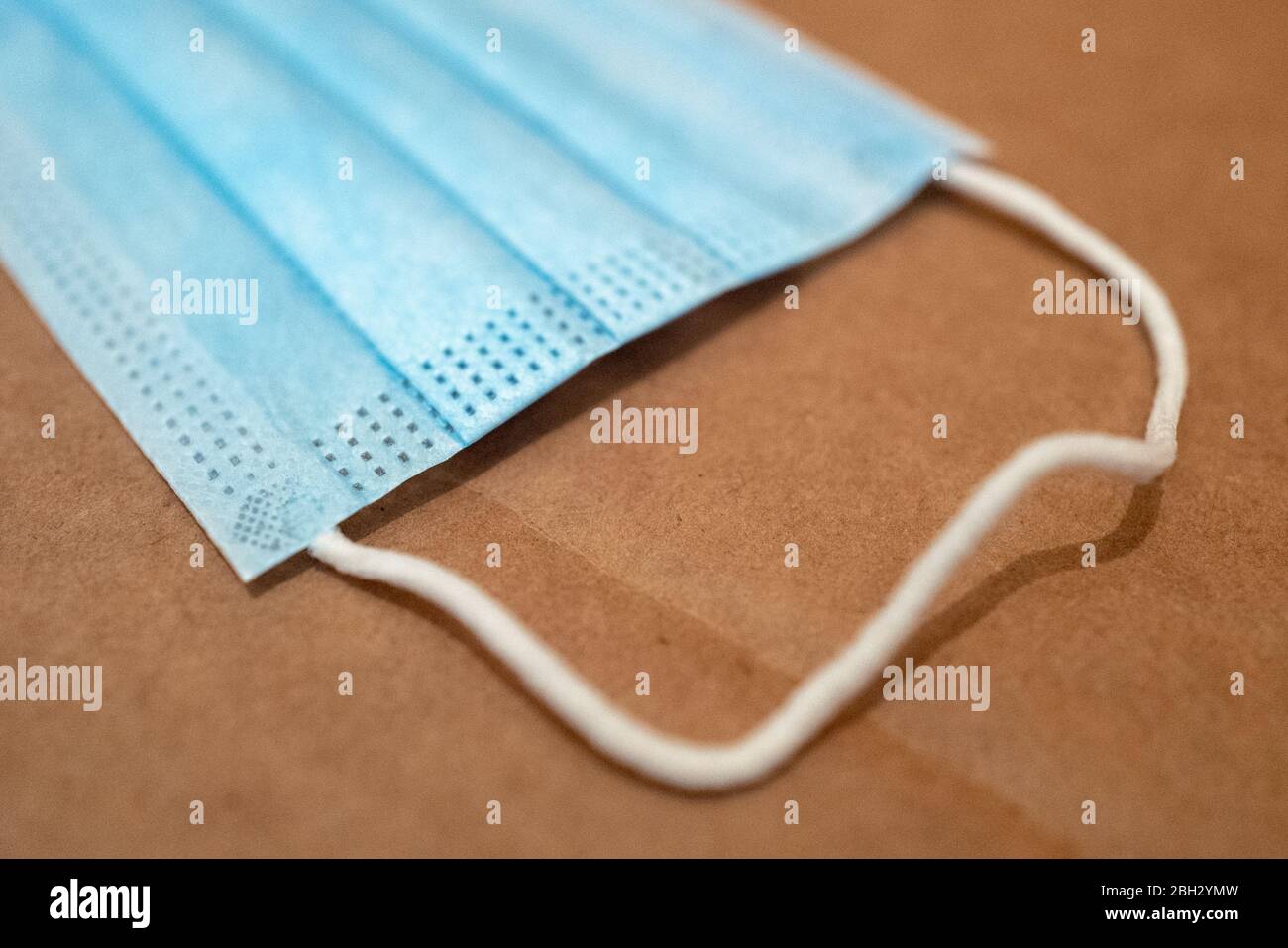 Detail view, close-up of blue color surgical mask with ear loops on ...