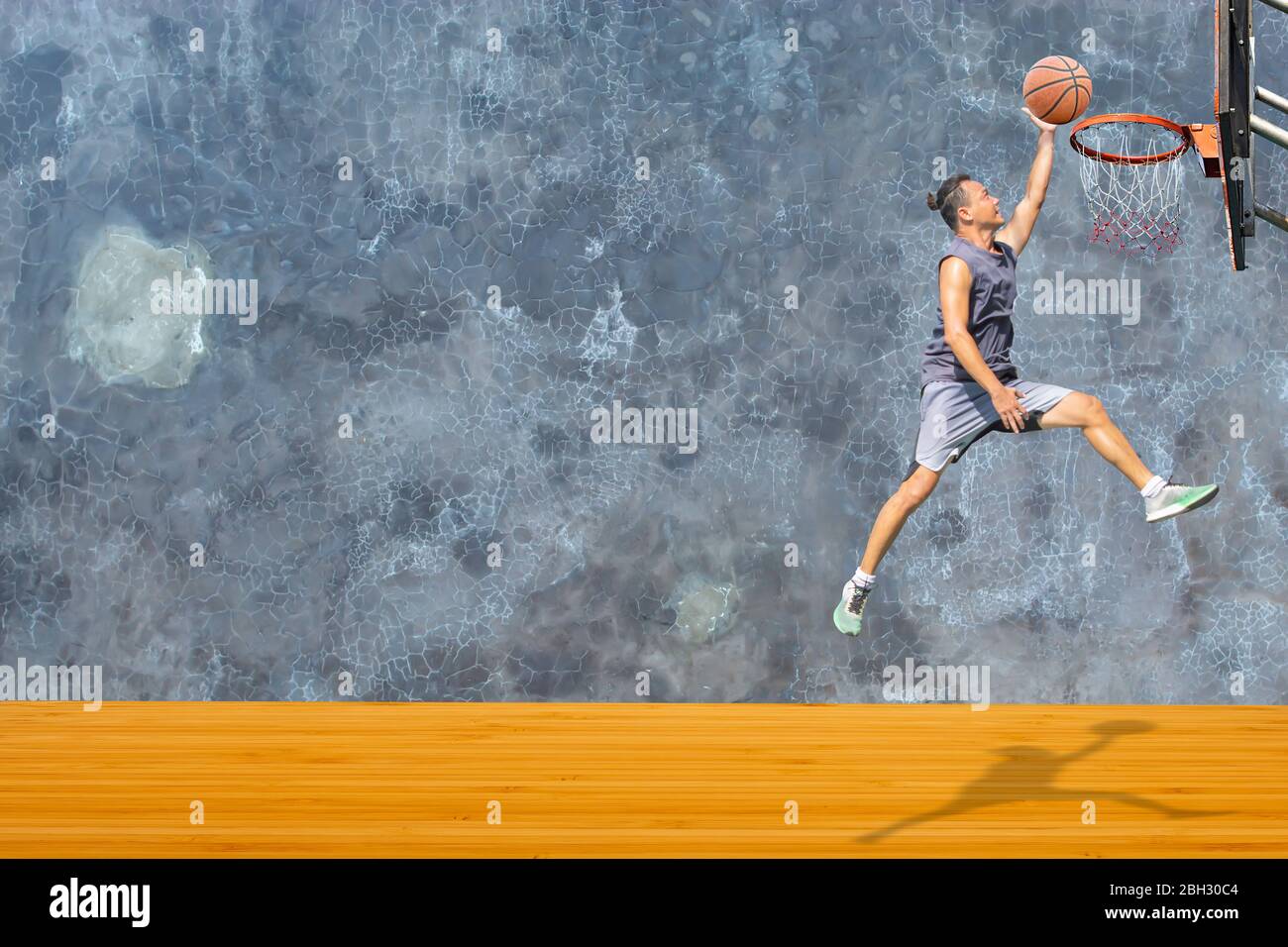 Basketball in hand man jumping Throw a basketball hoop On the wooden