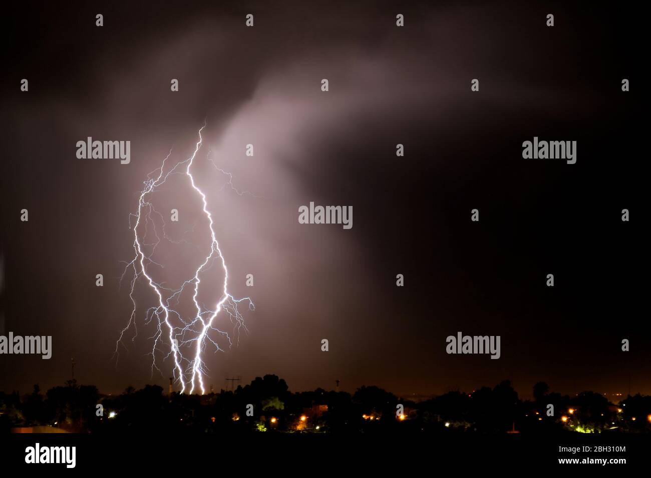 Lightning strikes at night during a severe thunderstorm over the city ...