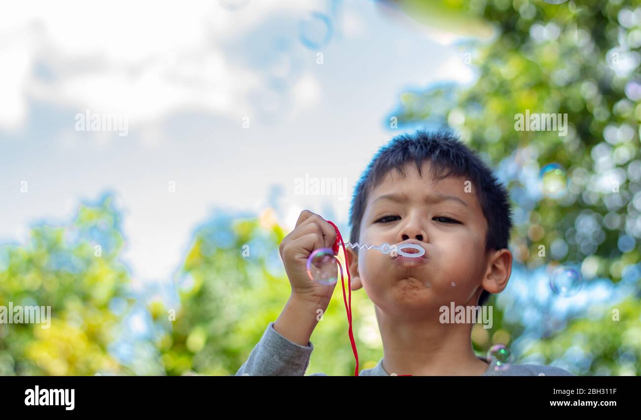 Portrait asia boy blowing bubbles  in garden. Stock Photo