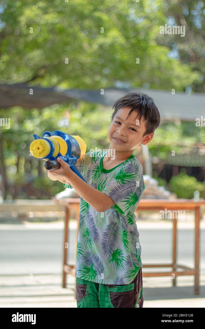 Asian boy holding a water gun play Songkran festival in Thailand. Stock Photo
