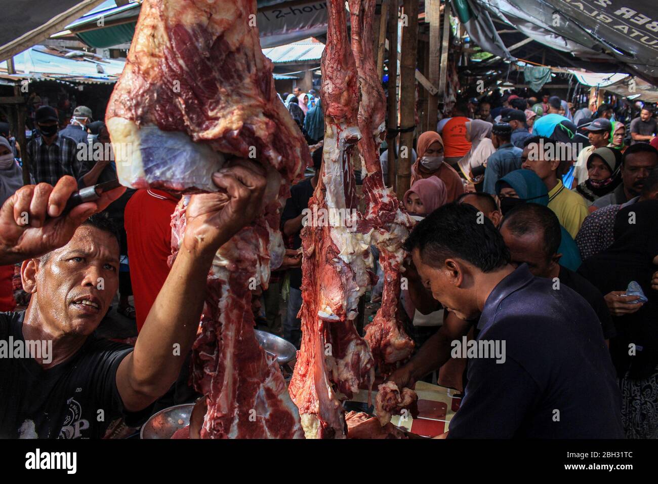 Lhokseumawe, Indonesia. 23rd Apr, 2020. A trader selling meat to buyers during the tradition. The people of Aceh still celebrated the 'Meugang' tradition even though it was banned due to concerns over the COVID-19 coronavirus outbreak. Welcoming the Holy Month of Ramadhan (Meugang) has been a tradition of Acehnese for hundreds of years. Credit: SOPA Images Limited/Alamy Live News Stock Photo
