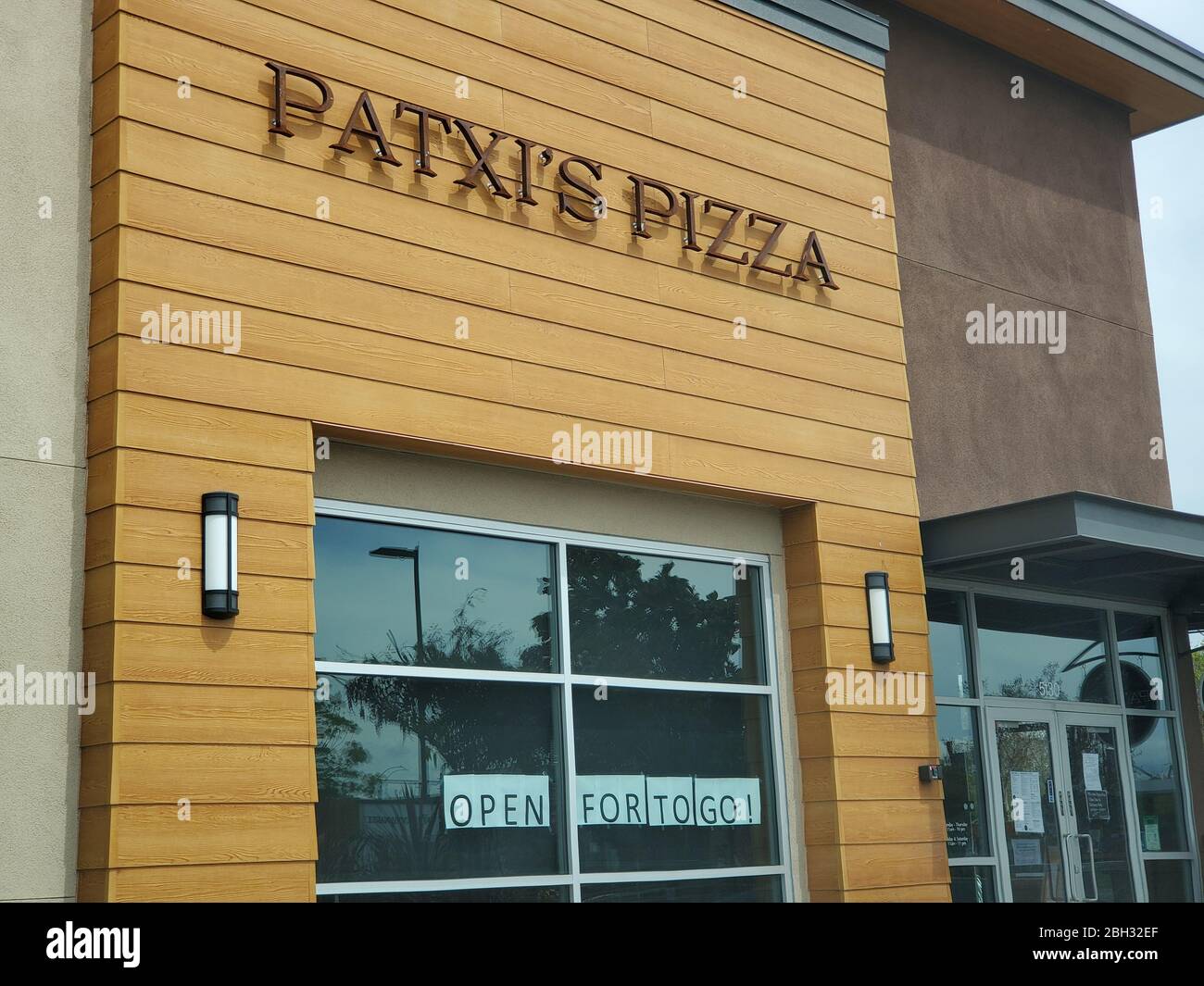 Facade of Patxi's Pizza with banner stating that the restaurant is open for takeout during an outbreak of the COVID-19 coronavirus in Dublin, California, April 8, 2020. () Stock Photo
