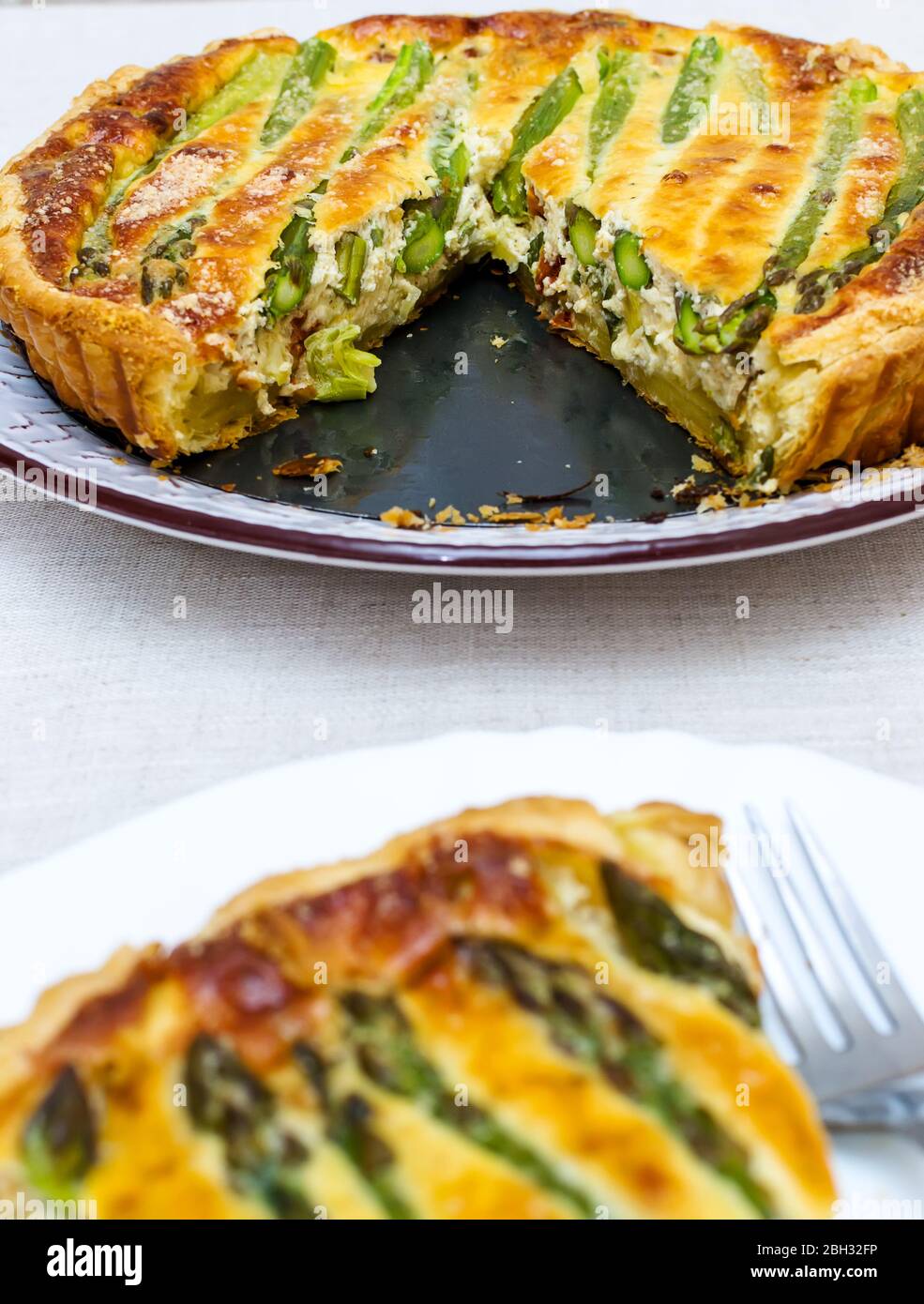 Tart with green asparagus and toasted cheese on the table Stock Photo