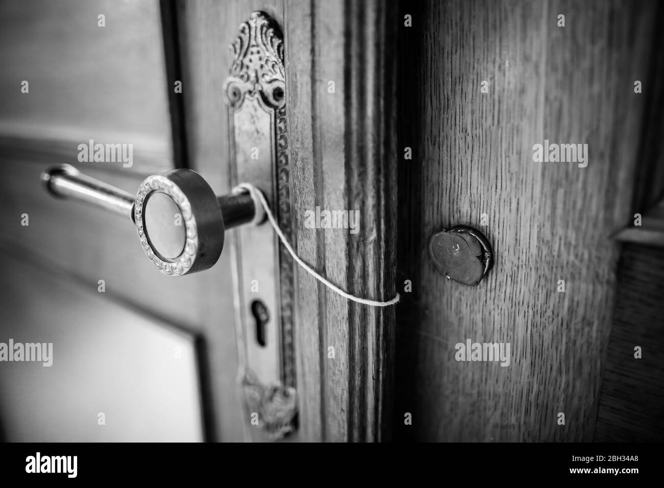 BW shallow depth of field (selective focus) details with a broken wax seal on an old massive wooden door. Stock Photo