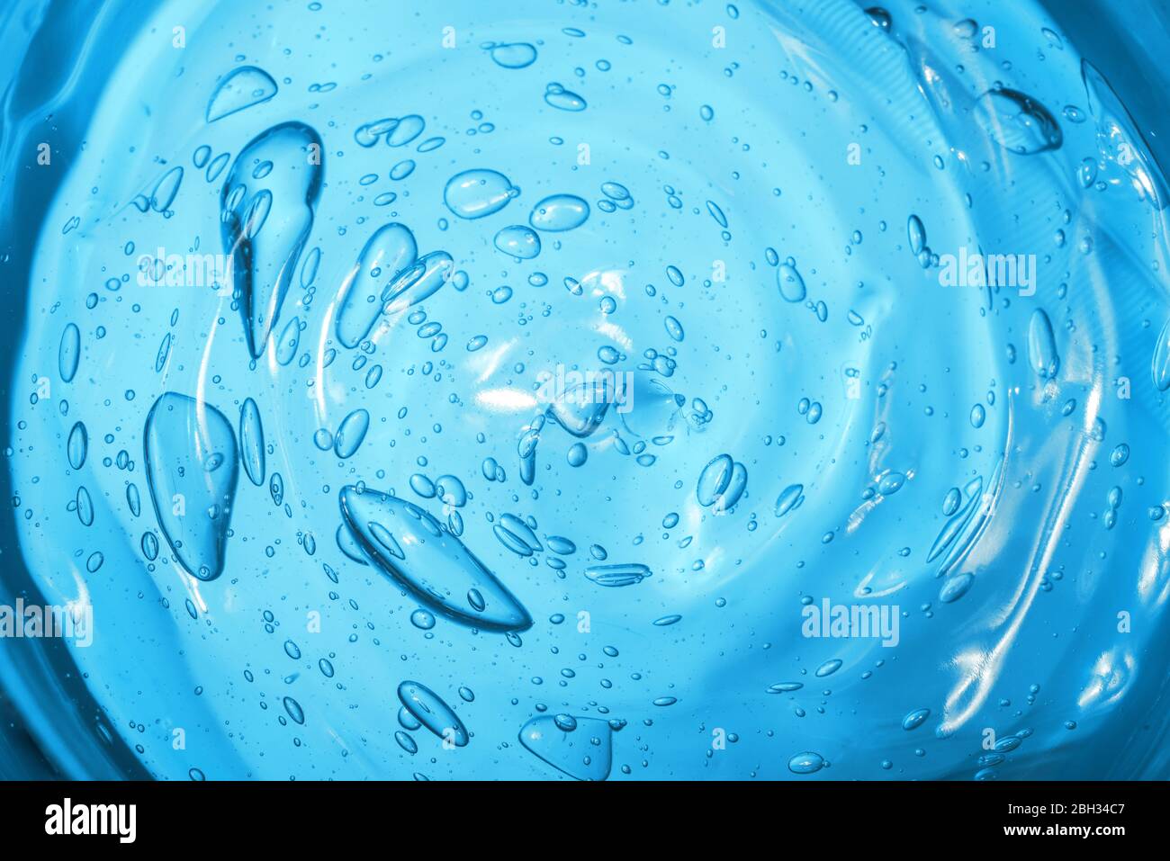 Hyaluronic acid cosmetic gel. Gel texture with bubbles on a blue