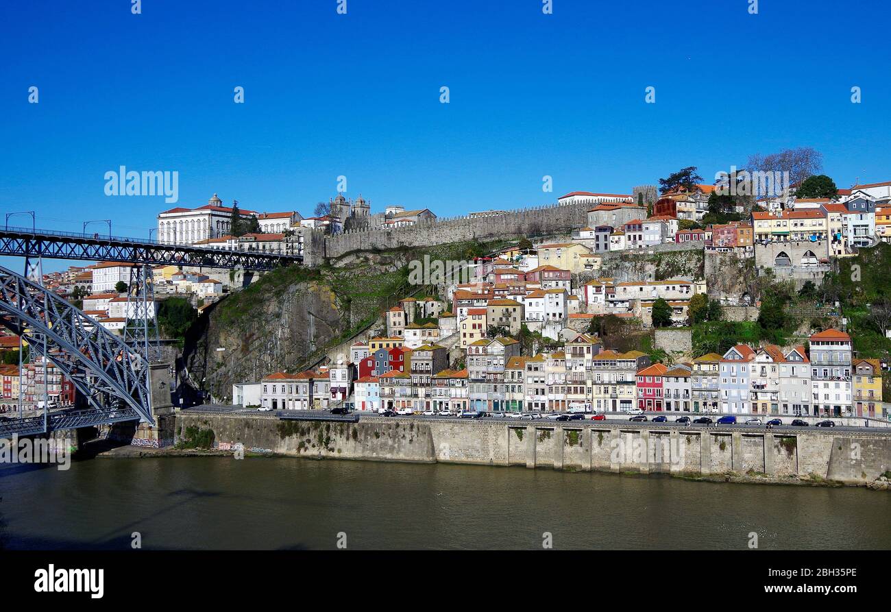 The steep-sided granite valley of the River Douro in Porto, Portugal, with the northern end of the Ponte Luis I, the Bishops’ palace & the city wall Stock Photo