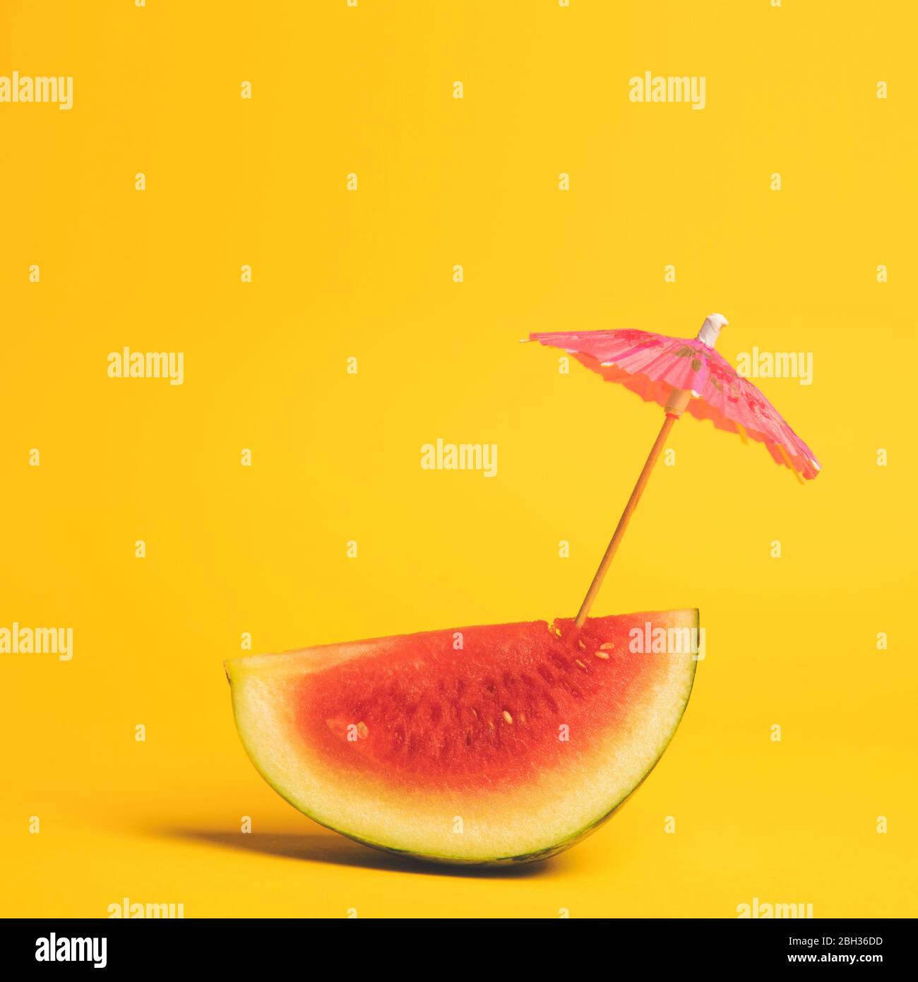 Watermelon and cocktail umbrella tropical summer background Stock Photo