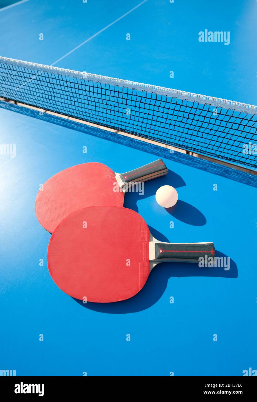 Table tennis bats and ball on table with net Stock Photo - Alamy