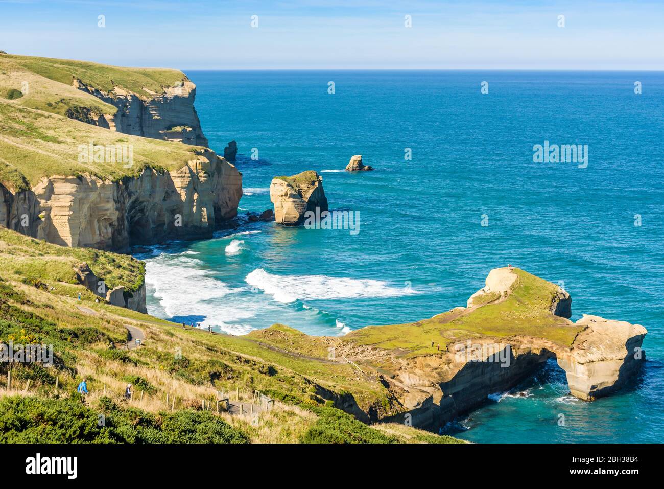 Sculpted cliffs, eroded rock formations and rough sea waves at Tunnel Beach, Otago region, South