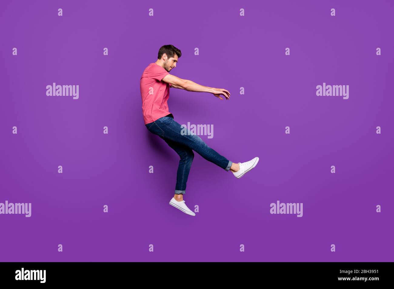 Full length profile side photo of minded guy jump wind blow he fall fly lose gravity weightlessness wear good look clothes gumshoes isolated over Stock Photo