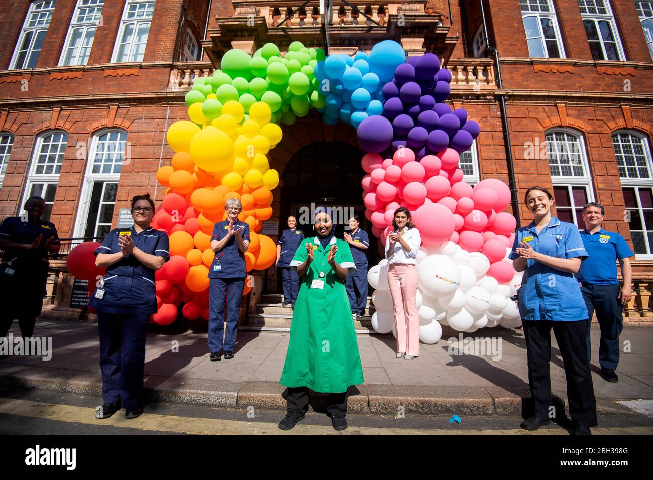 NHS nurses, surgeons, doctors and support staff help to unveil a rainbow balloon display outside the National Hospital for Neurology and Neurosurgery in Holborn, London to thank the public for their support during the ongoing Coronavirus pandemic. Stock Photo