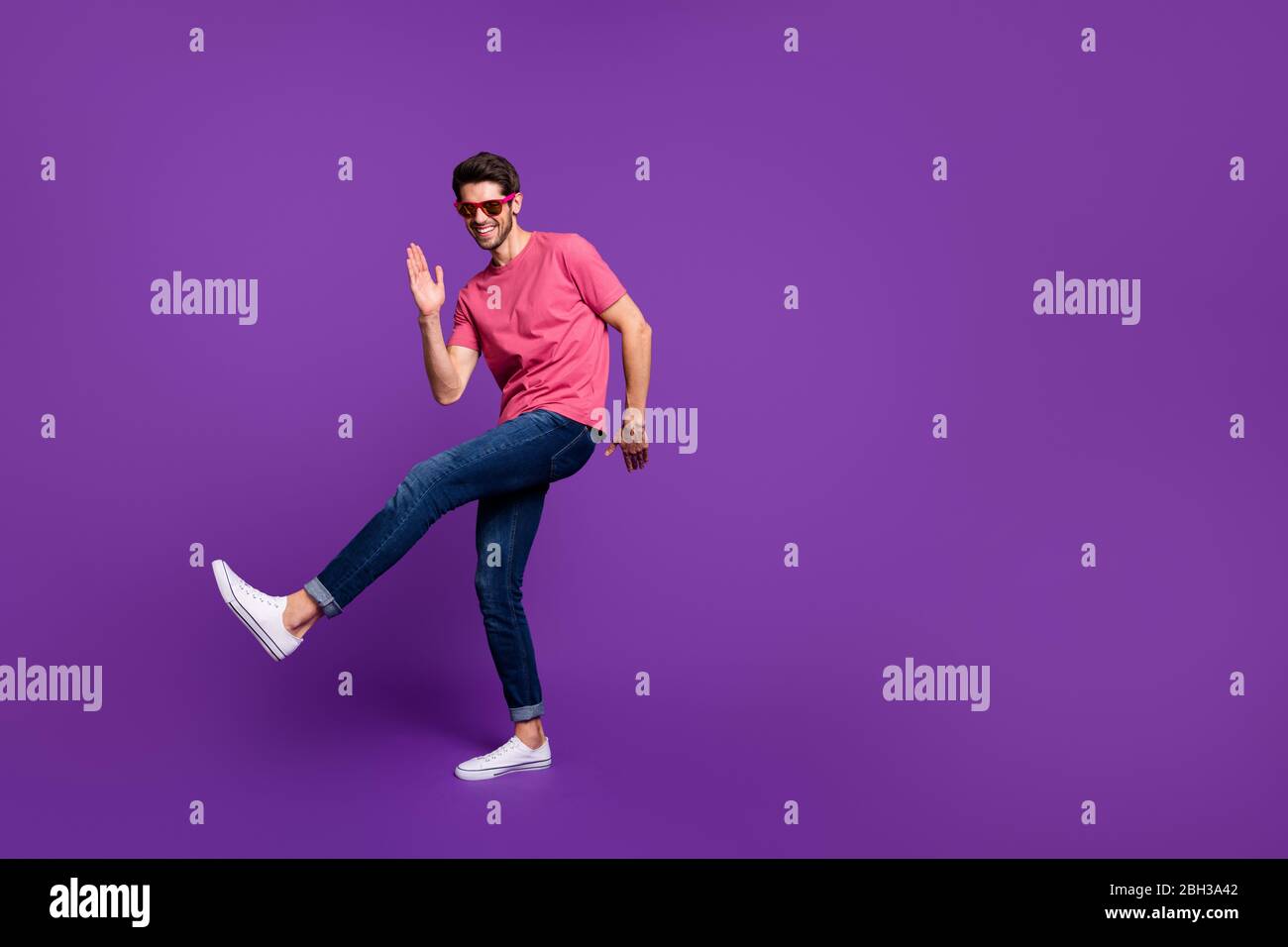 Full size photo of cheerful candid funny guy dance discotheque enjoy music night club wear good look outfit gumshoes isolated over purple shine color Stock Photo