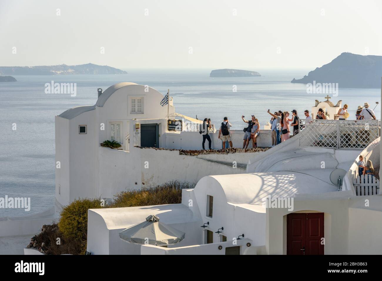 Tourists taking selfies on a rooftop in Oia, Santorini Stock Photo