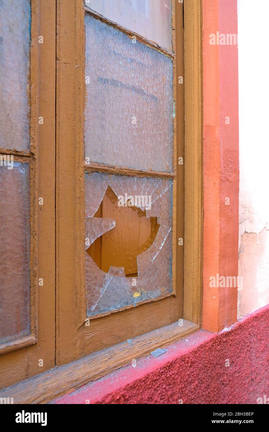 Broken window with smashed glass pane. Stock Photo