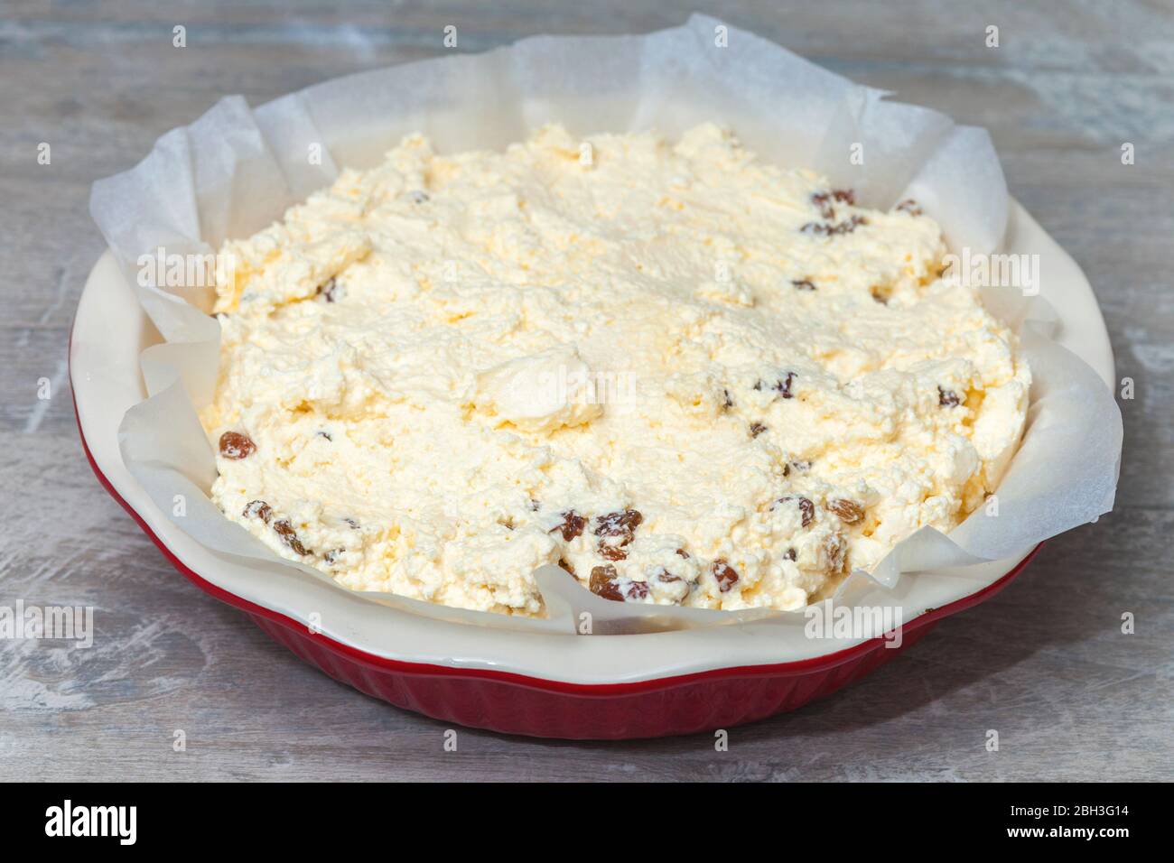 raw cottage cheese casserole dough in a round ceramic baking dish Stock Photo