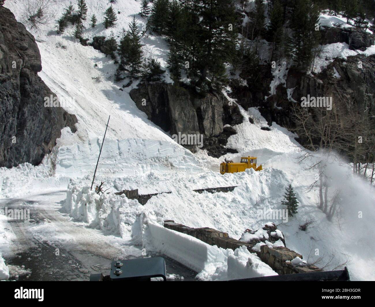 Snow removal equipment along the winding Going-To-The-Sun road at an elevation of 6,646 feet in Glacier National Park April 21, 2020 in Glacier, Montana. Road clearing continues despite the park being closed to visitors due to the COVID-19, coronavirus pandemic. Stock Photo