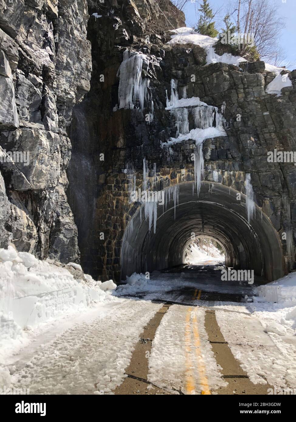 The West Side Tunnel now cleared of snow along the winding Going-To-The-Sun road at an elevation of 6,646 feet in Glacier National Park April 14, 2020 in Glacier, Montana. Road clearing continues despite the park being closed to visitors due to the COVID-19, coronavirus pandemic. Stock Photo