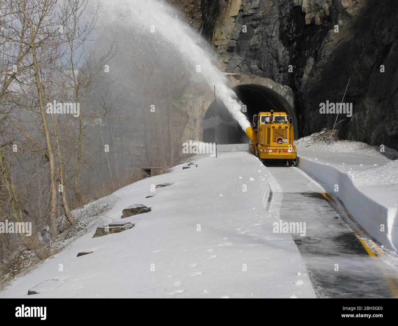 Snow removal equipment at the West Side Tunnel along the winding Going-To-The-Sun road at an elevation of 6,646 feet in Glacier National Park April 14, 2020 in Glacier, Montana. Road clearing continues despite the park being closed to visitors due to the COVID-19, coronavirus pandemic. Stock Photo