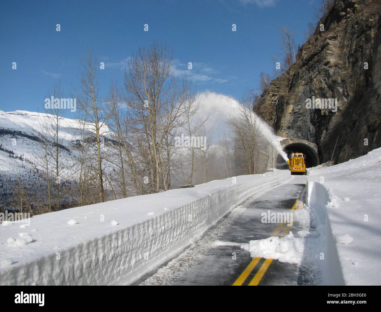 Snow removal equipment at the West Side Tunnel along the winding Going-To-The-Sun road at an elevation of 6,646 feet in Glacier National Park April 14, 2020 in Glacier, Montana. Road clearing continues despite the park being closed to visitors due to the COVID-19, coronavirus pandemic. Stock Photo