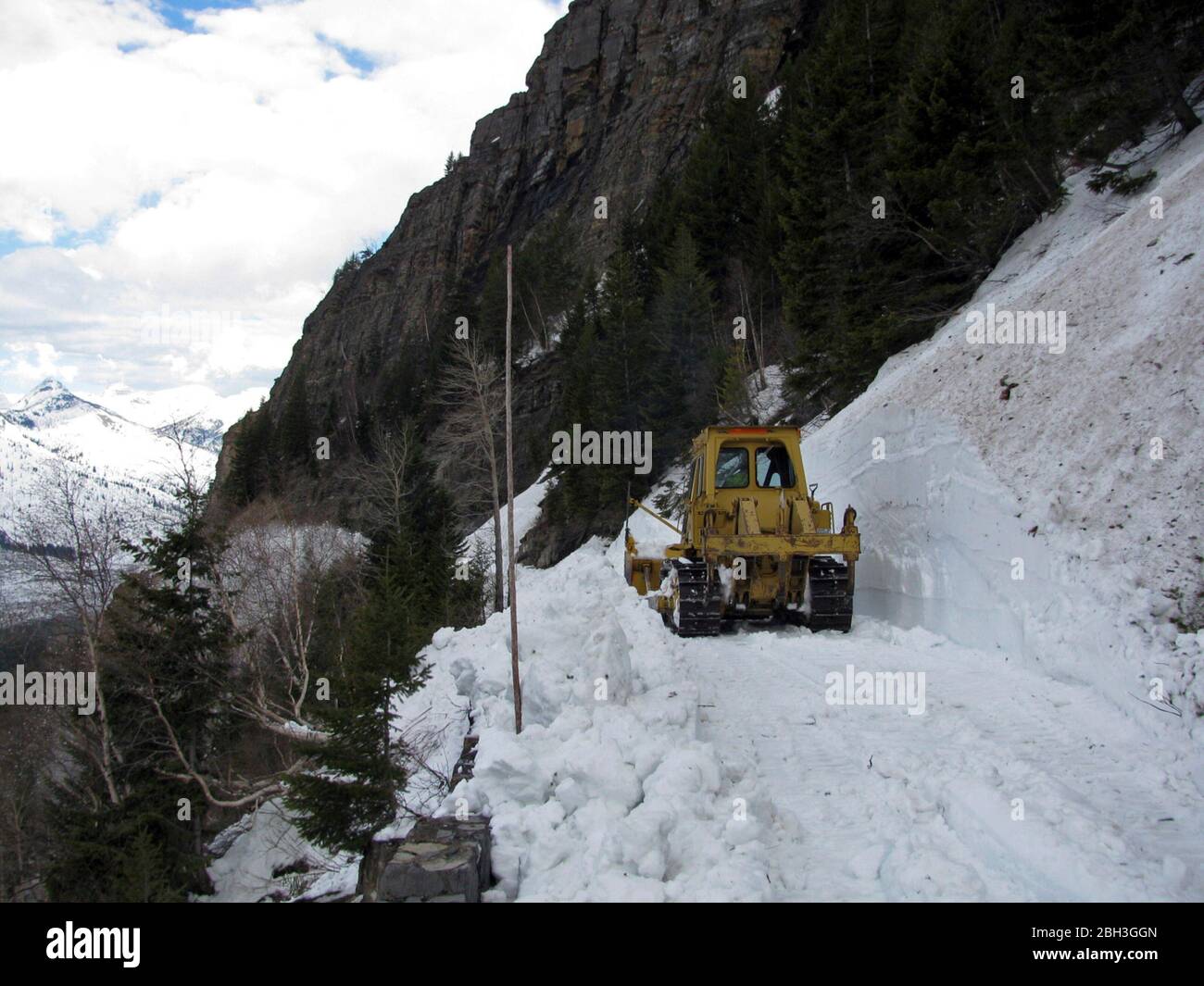 Snow removal equipment along the winding Going-To-The-Sun road at an elevation of 6,646 feet in Glacier National Park April 21, 2020 in Glacier, Montana. Road clearing continues despite the park being closed to visitors due to the COVID-19, coronavirus pandemic. Stock Photo