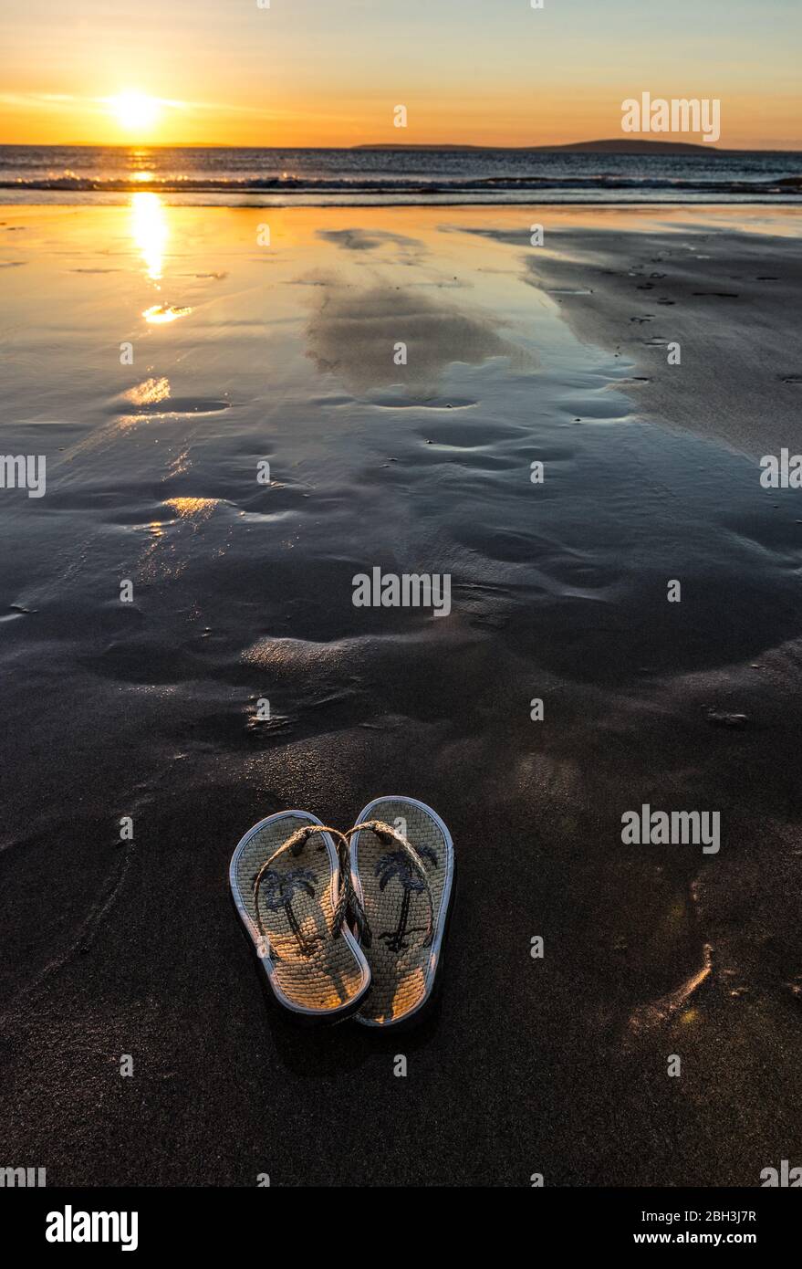 Flip flop sandals on the beach sand at sunset Stock Photo - Alamy