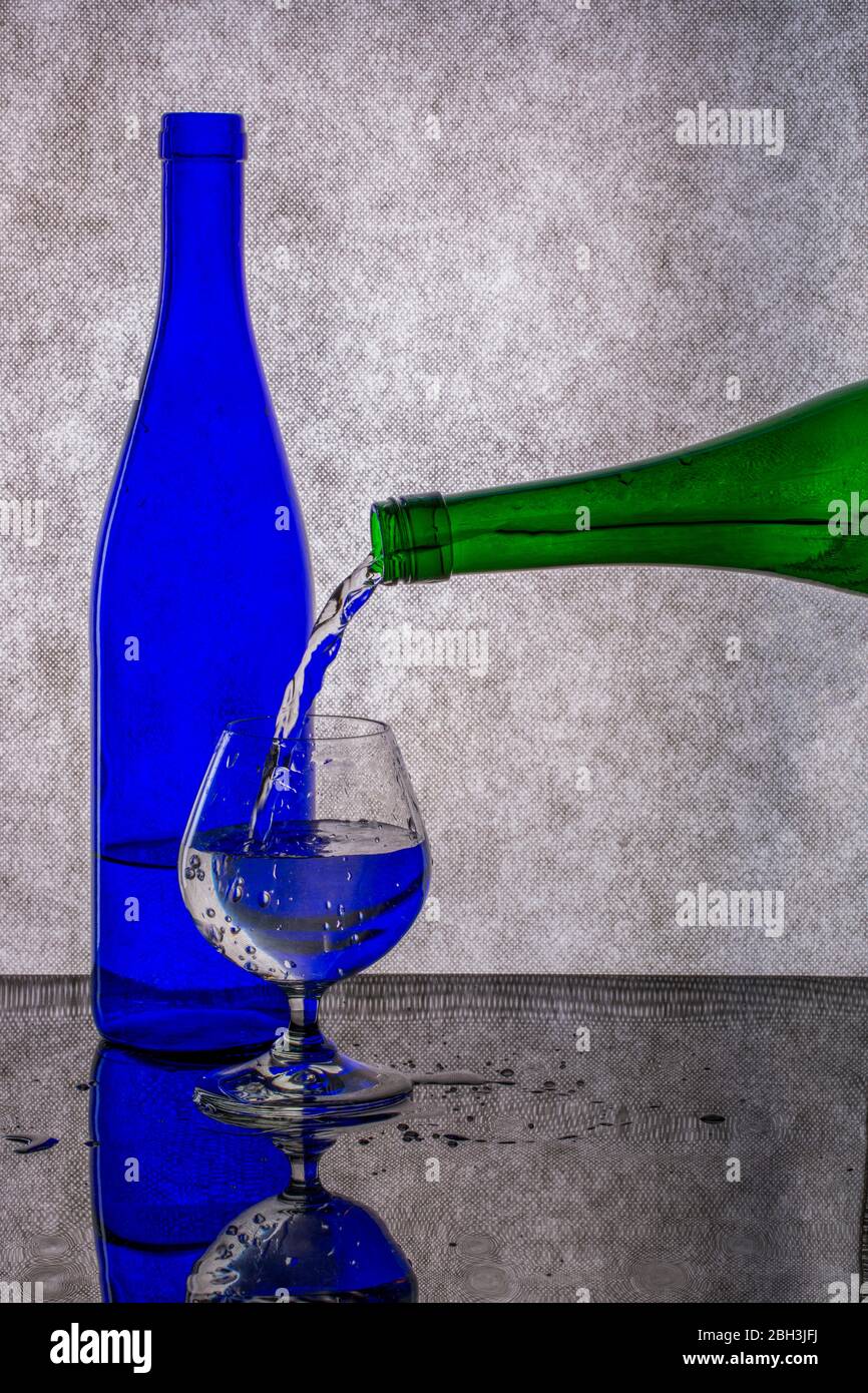 Pouring liquid from a green bottle into a glass Stock Photo Alamy