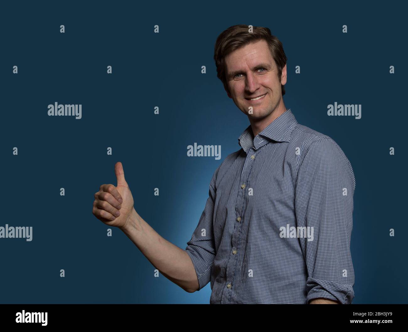 Man Giving the Thumbs Up and Smiling Stock Photo