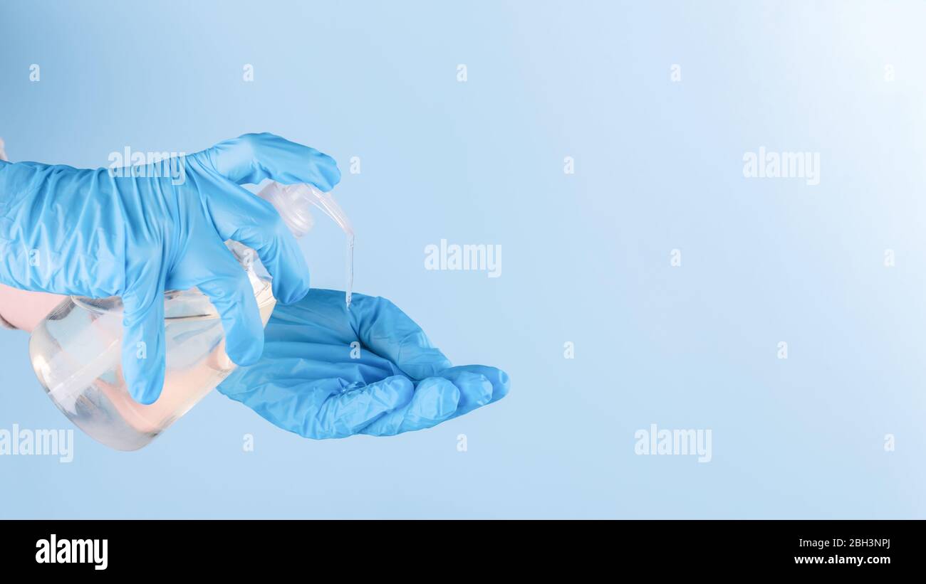 Female hand in latex surgical gloves is using antiseptic hand sanitizer