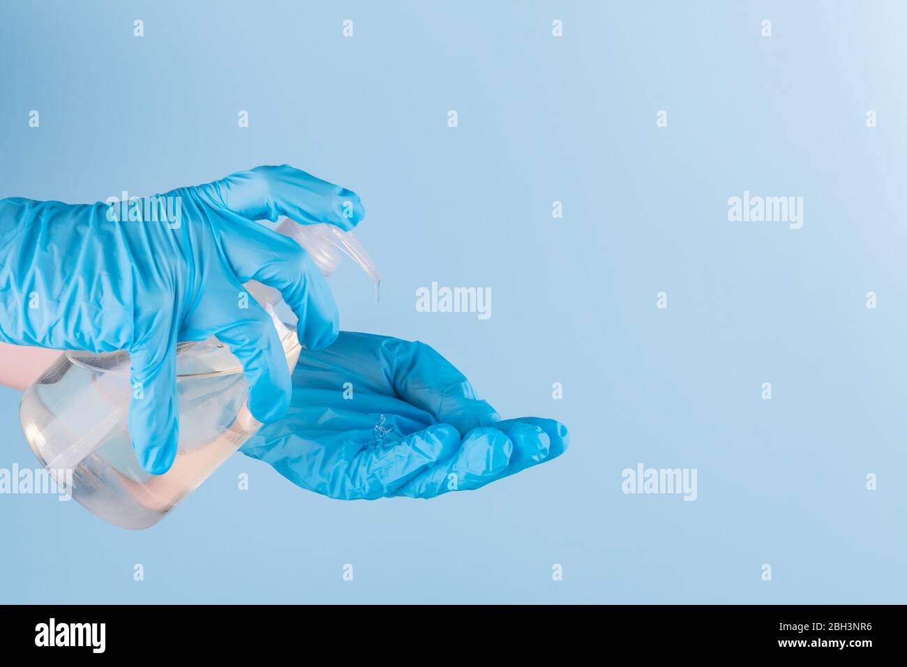 Female hand in latex surgical gloves is using antiseptic hand sanitizer
