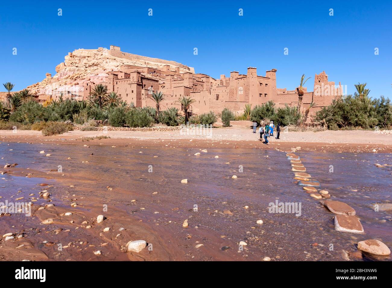 Stones as crossing point via Ounila River and the Historic ighrem or ksar (fortified village), Aït Benhaddou, Morocco Stock Photo