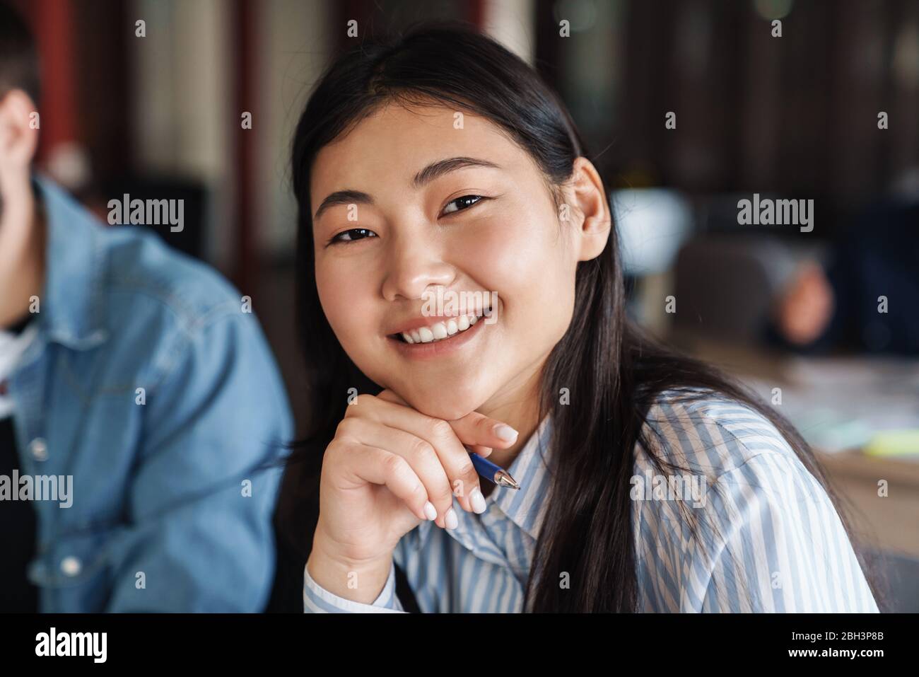 Photo of asian cheerful student in casual wear smiling and looking at ...