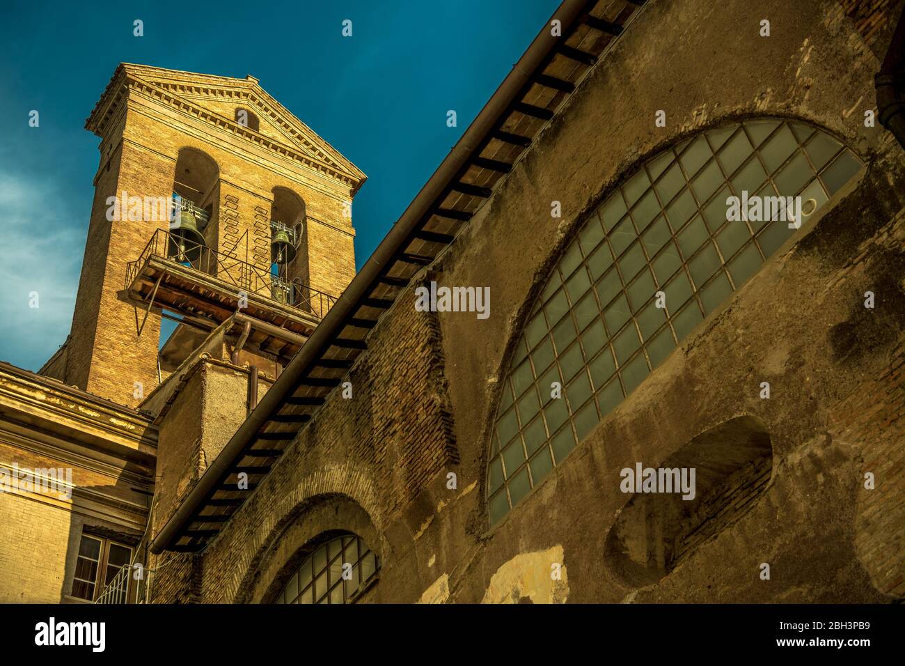 Church Bells On Top of Tall Tower In Historical Building In Rome. Stock Photo