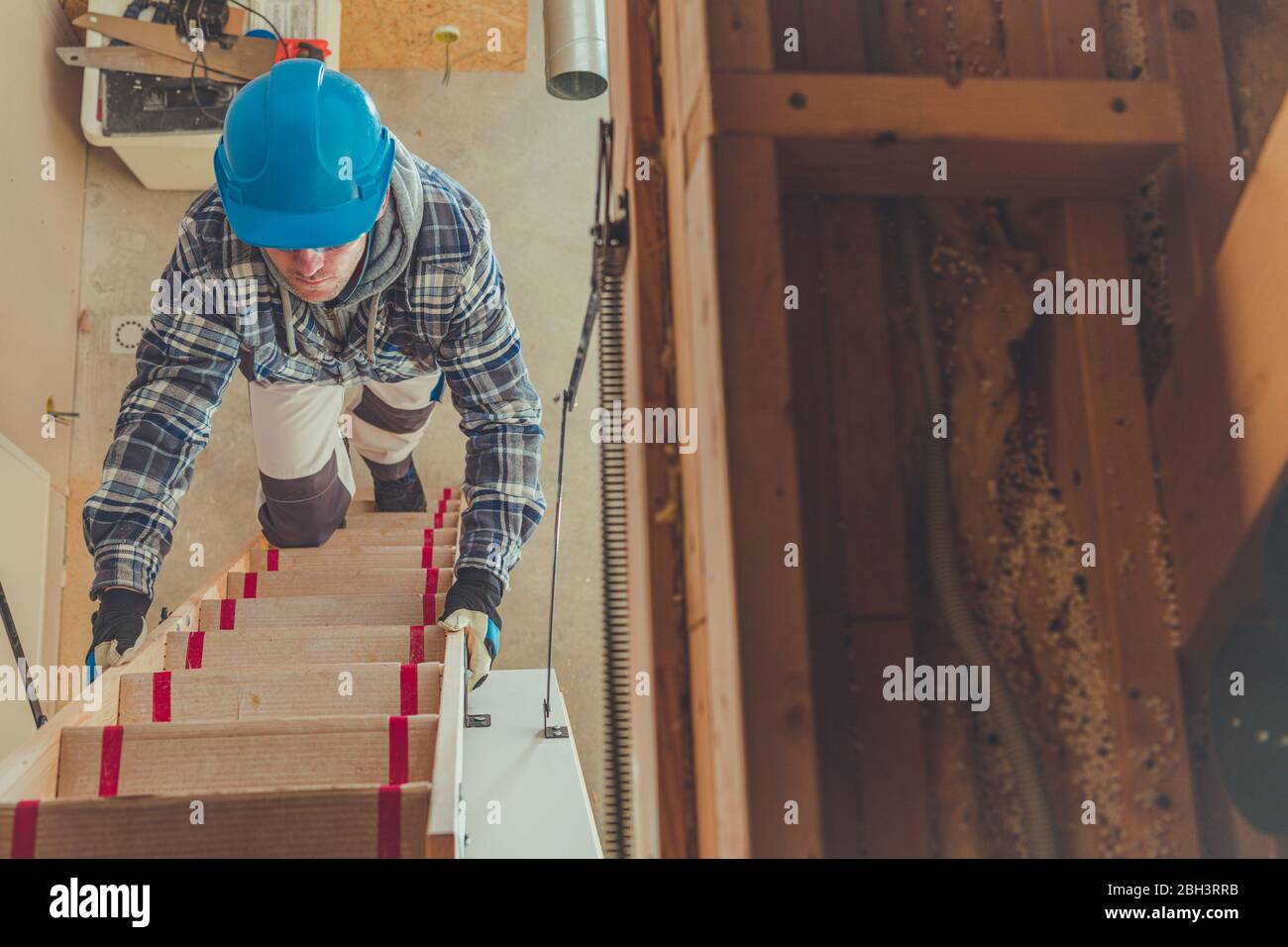 Construction Contractor Climbing Up Unfinished Steps To Access Upper Floor Of Building. Stock Photo