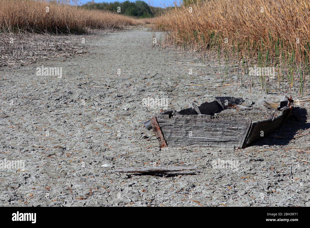 old sunken boat appears in a river bed that has dried up due to drought Stock Photo