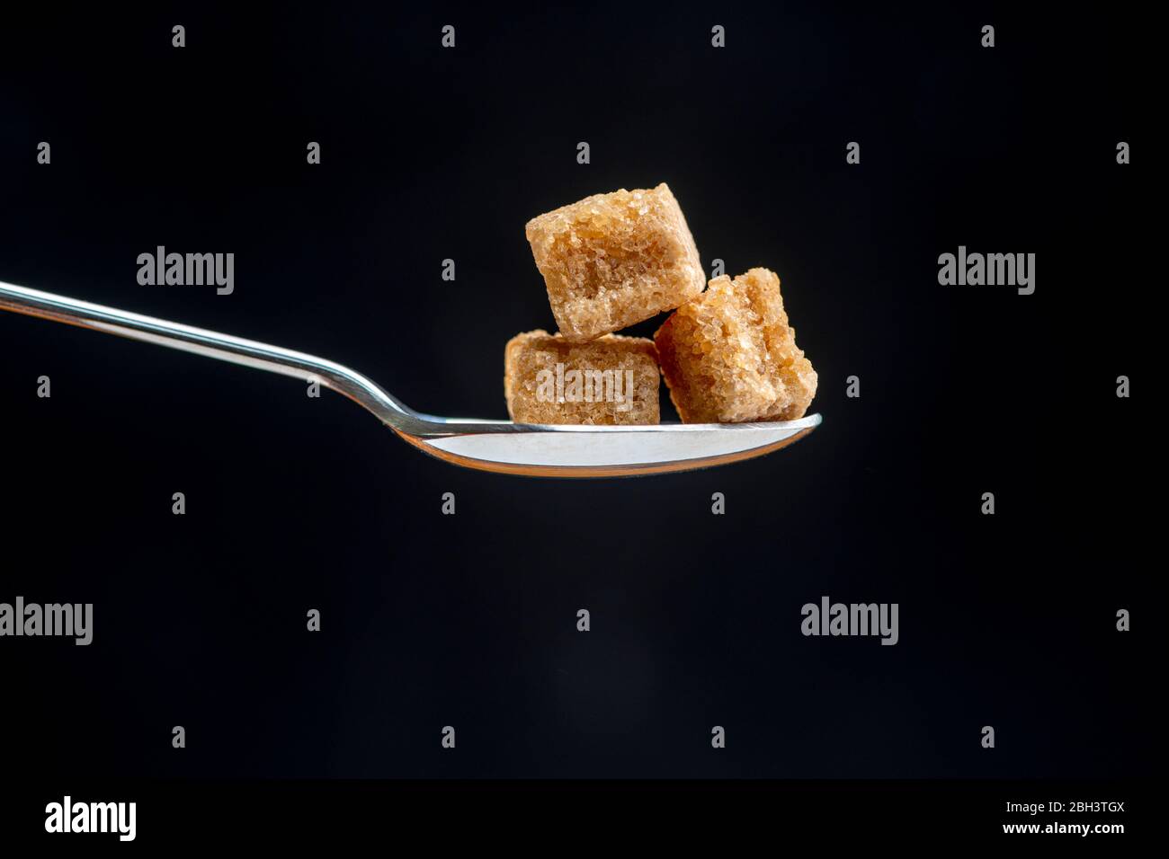 spoon with cubes of brown demerara sugar Stock Photo