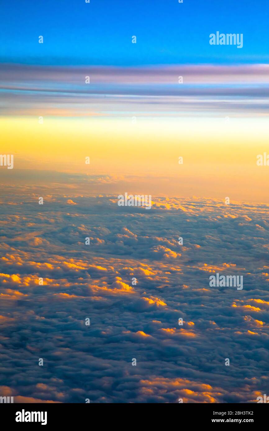 View above the clouds at sunset while flying in a plane Stock Photo - Alamy