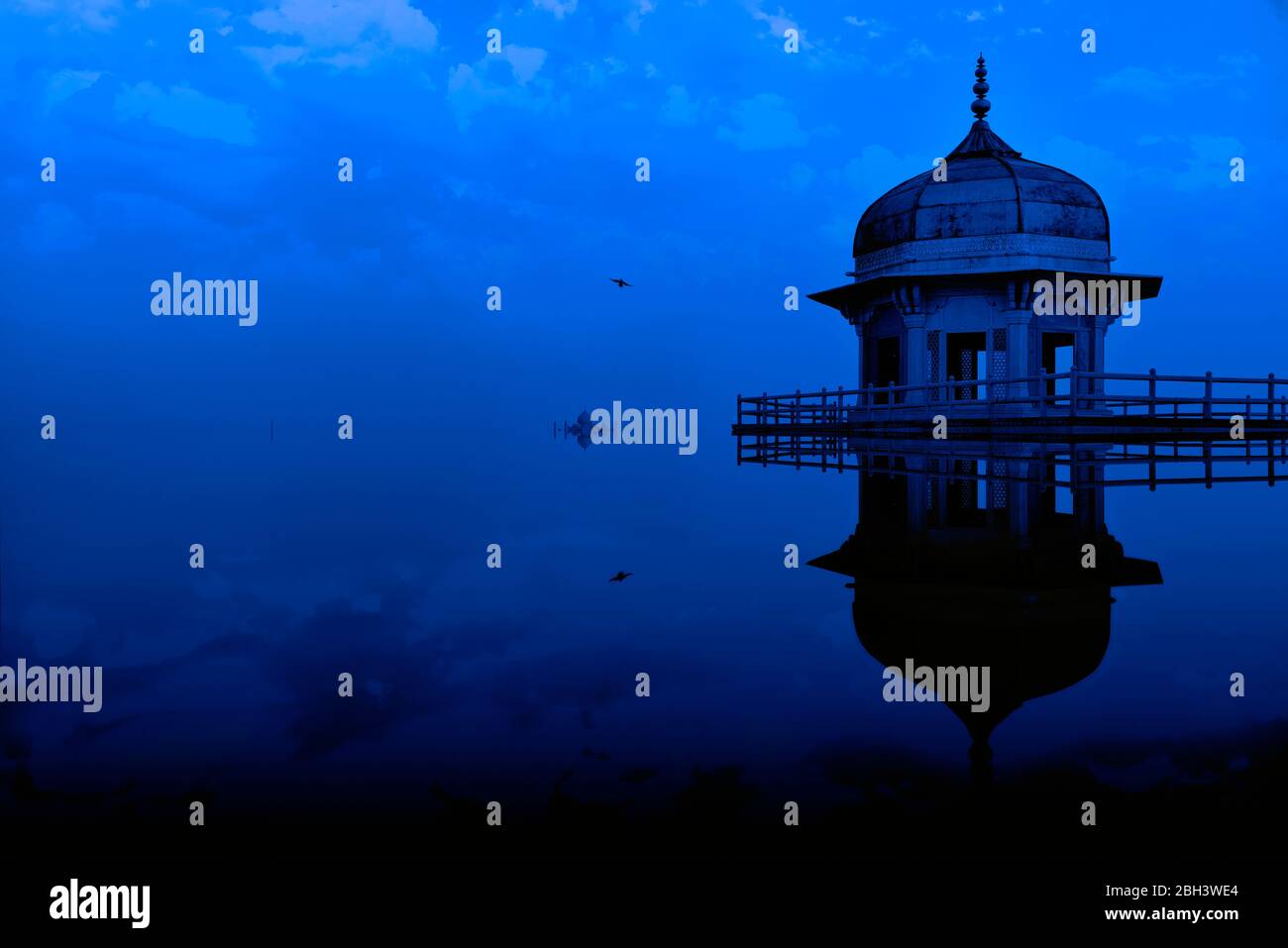 Digital manipulation conceptual image of Jasmine tower, in Agra fort, appearing partially submerged in water with a beautiful blue evening sky. Stock Photo