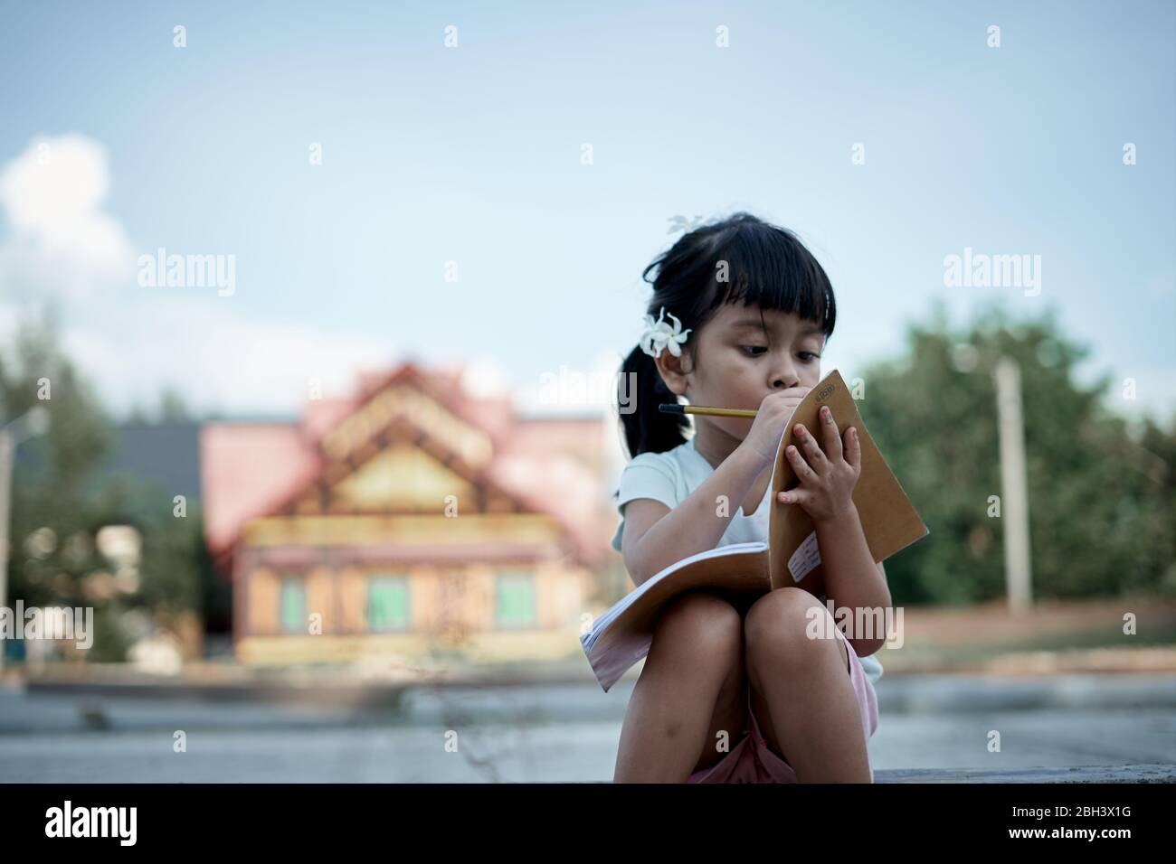 Little girl writing and studying at home, study from home during a coronavirus  outbreak Stock Photo