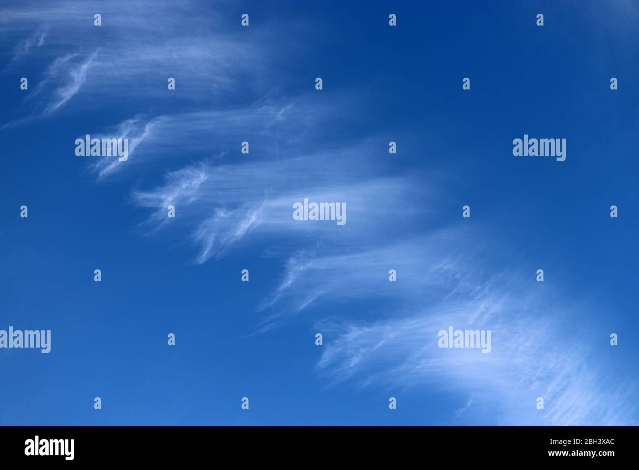 Blue sky covered with white cirrus clouds. Spring cloudscape, beautiful weather background, abstract pattern Stock Photo