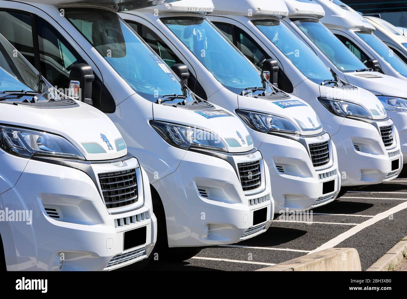 A selection of autosleeper motor homes for sale on a garage forecourt