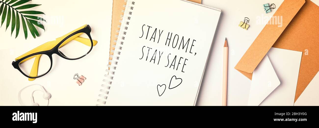 Words stay home, stay safe written in notebook, concept of self quarantine coronavirus at home, Home office concept. Stock Photo