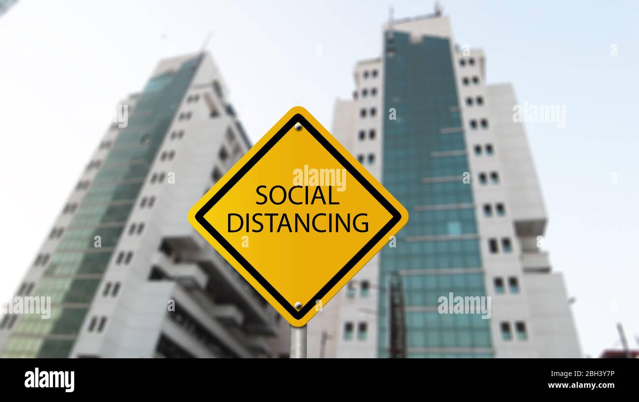 Social Distancing warning sign against business building Stock Photo
