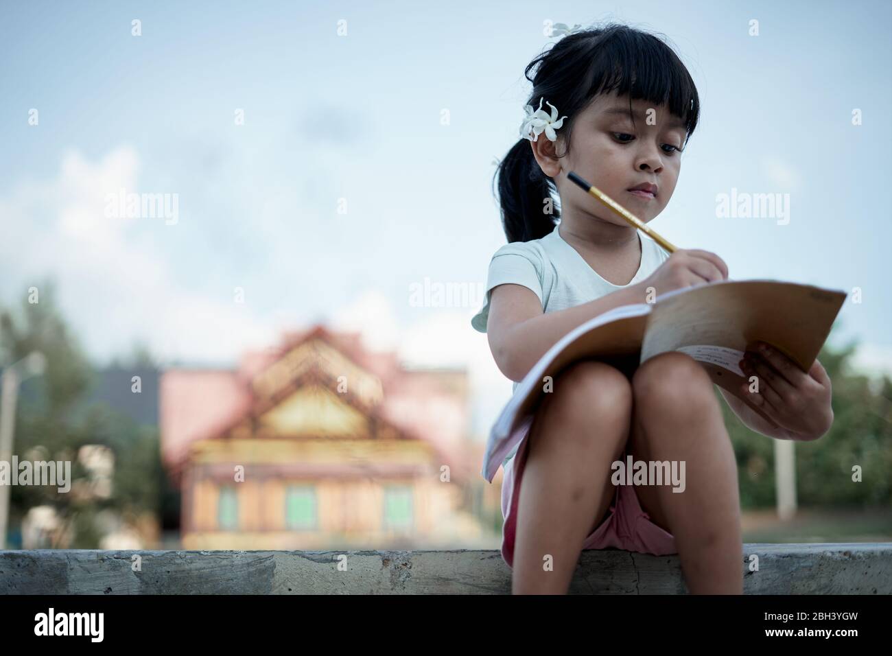 Little girl writing and studying at home, study from home during a coronavirus  outbreak Stock Photo