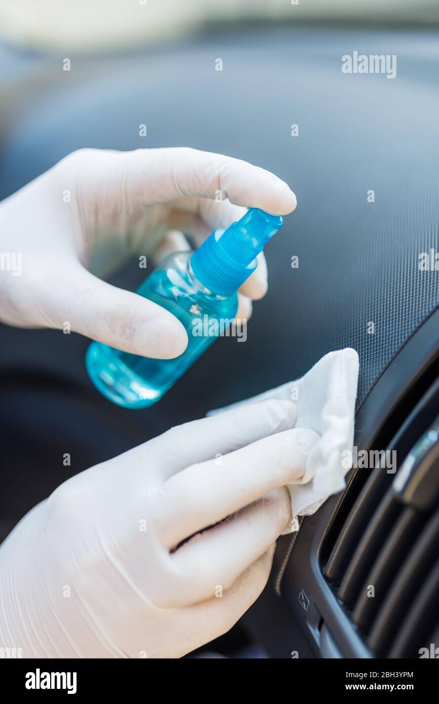 Professional worker using disinfectant and wet wipe to clean car interior Stock Photo Alamy