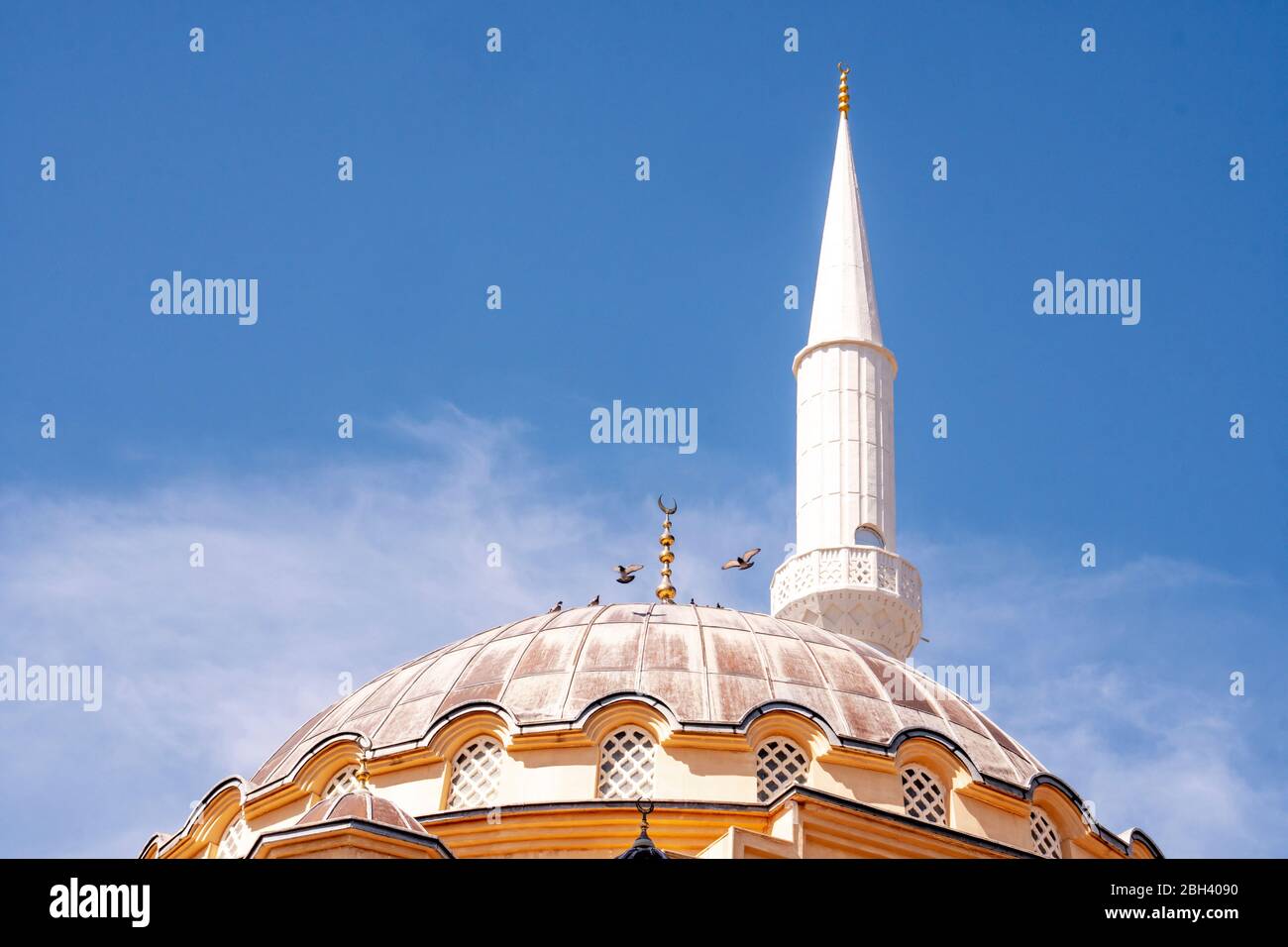 The dome and tower of a big mosque on on day light with blue sky night background. Ramadan concept. High quality photo Stock Photo