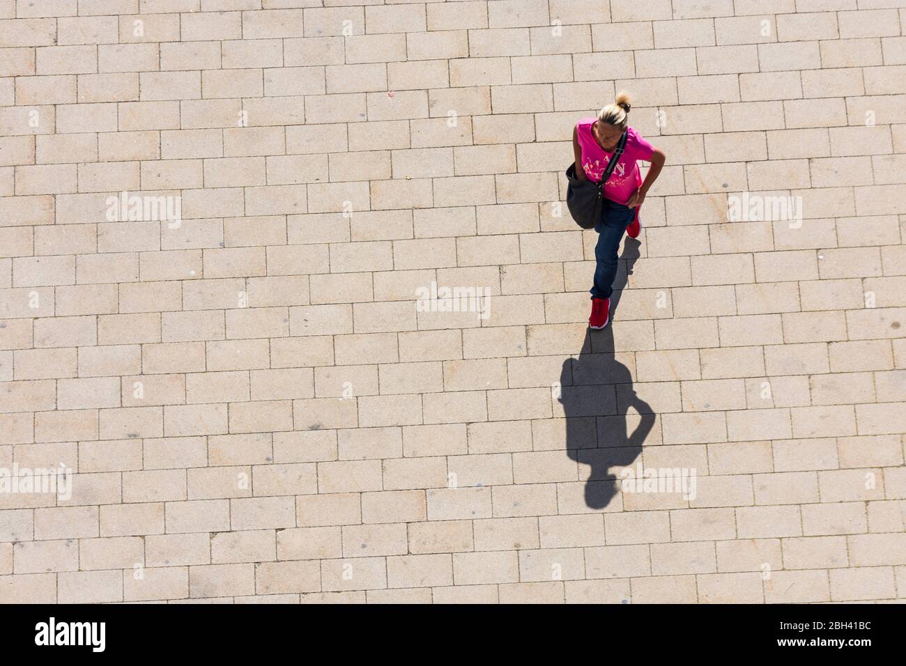 Wien, Vienna: woman walking alone, long shadow, in , Wien, Austria Stock Photo