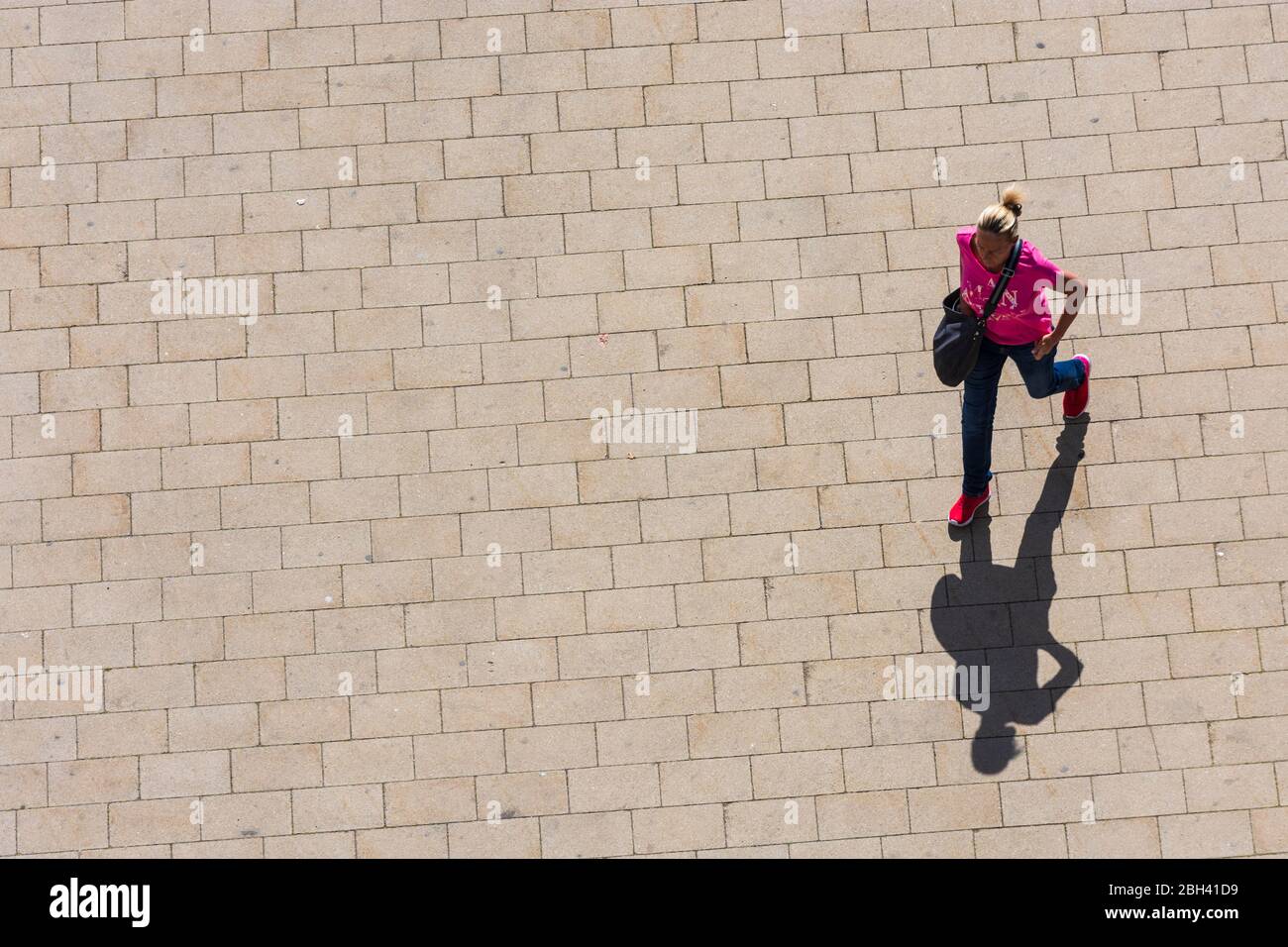 Wien, Vienna: woman walking alone, long shadow, in , Wien, Austria Stock Photo