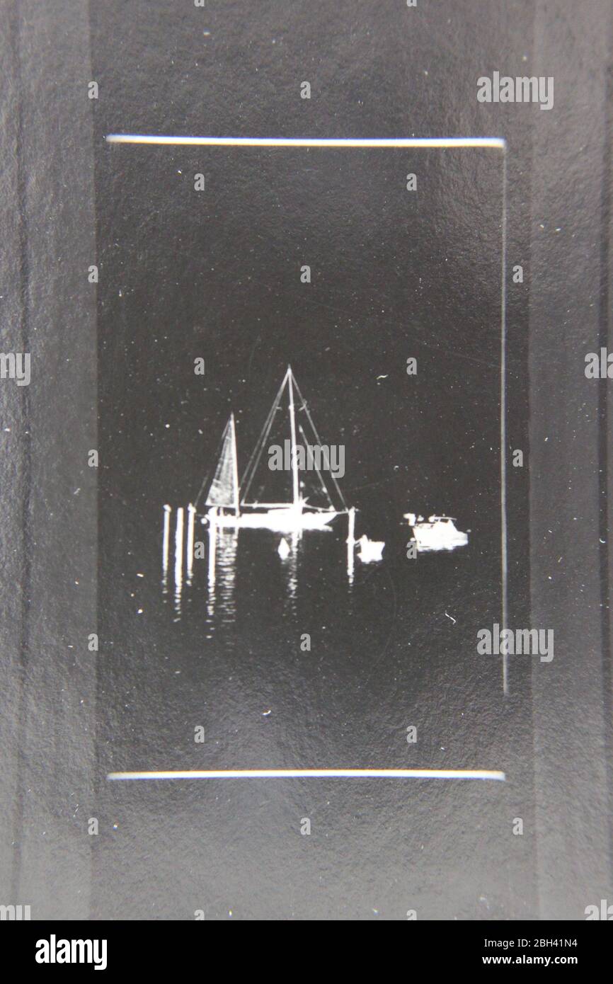 Fine 70s vintage extreme high contrast contact print photography of  a small flotilla of sailboats floating around calm waters Stock Photo